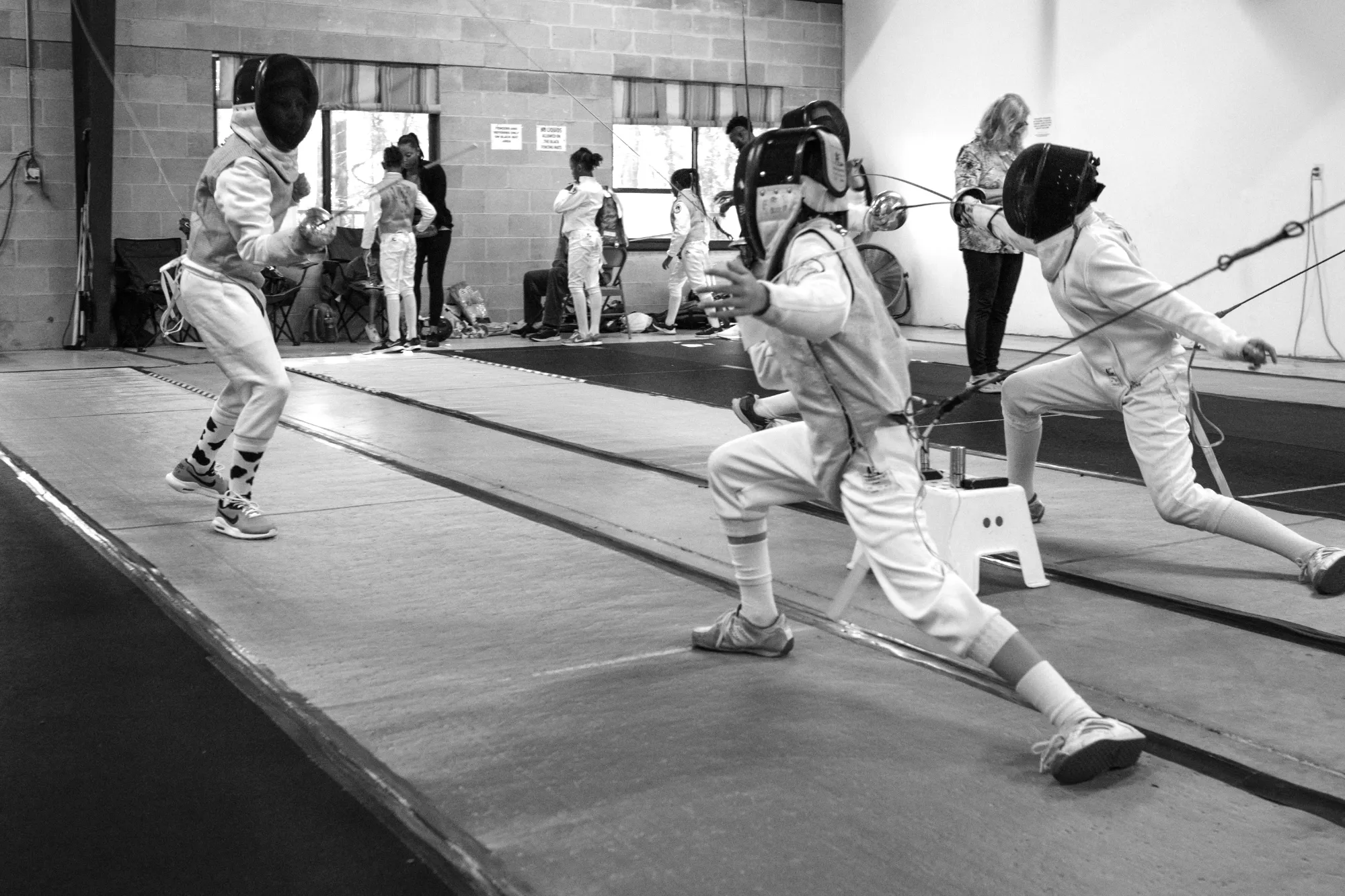 Young fencers bouting on the strip